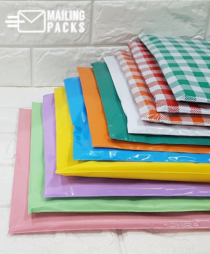 pastel, green, pink, violet, yellow, blue, orange, dark green, white and checkered color plastic mailing bags on top of each other on the table